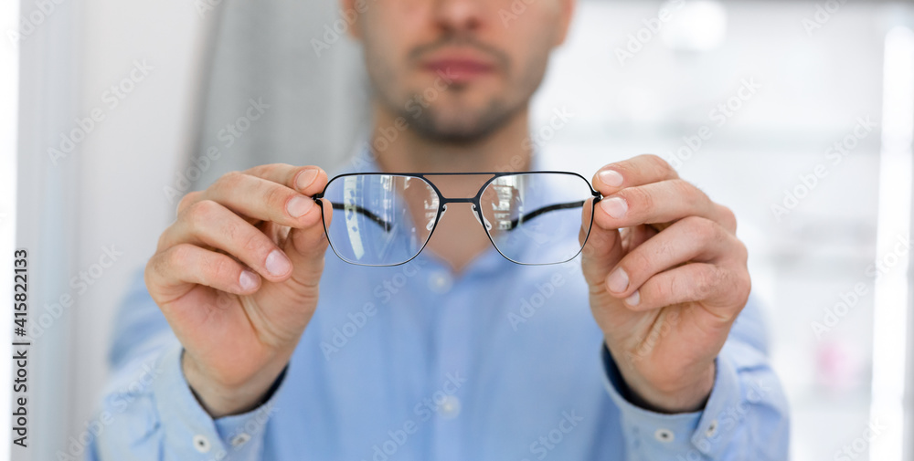 Fototapeta premium Closeup portrait of man showing spectacles to camera