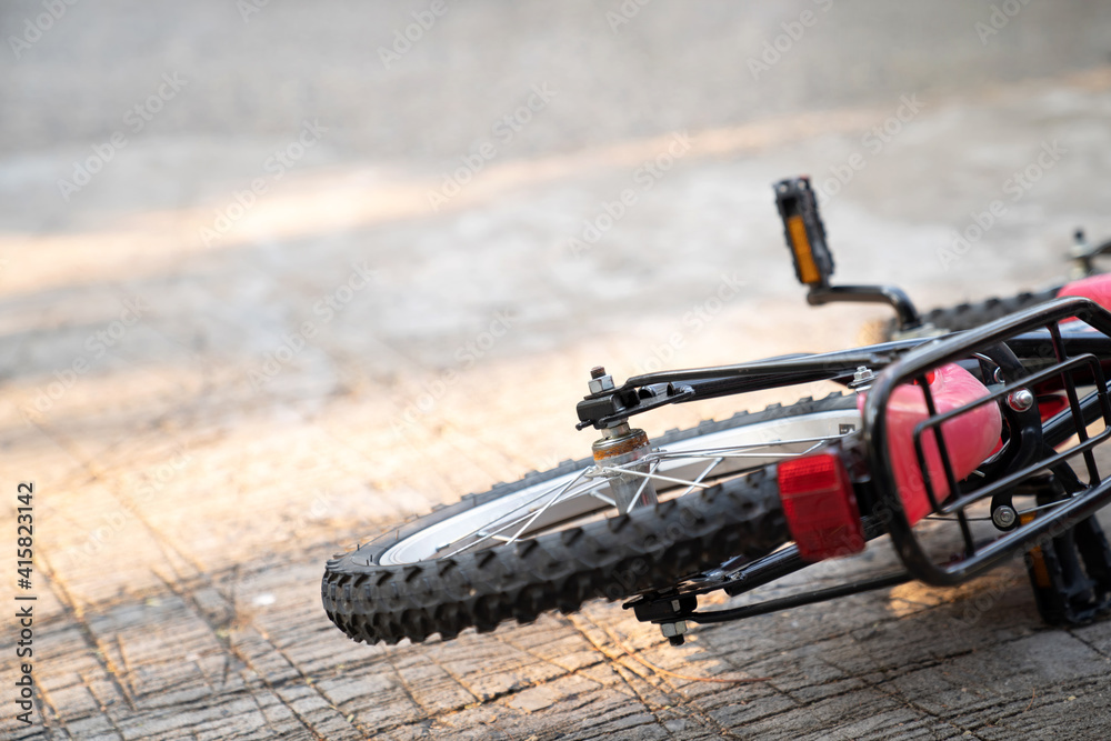 Close up of bicycle falling on the ground under sunlight. Selective focus on Hex nut. Accident and bike safety. Learning to bike bicycle. No people. Rust on the back wheel.. Close up of bicycle falling on the ground under sunlight. Selective focus on Hex nut. Accident and bike safety. Learning to bike bicycle. No people. Rust on the back wheel..