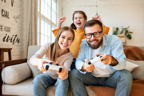 Girl supporting parents playing videogame photo