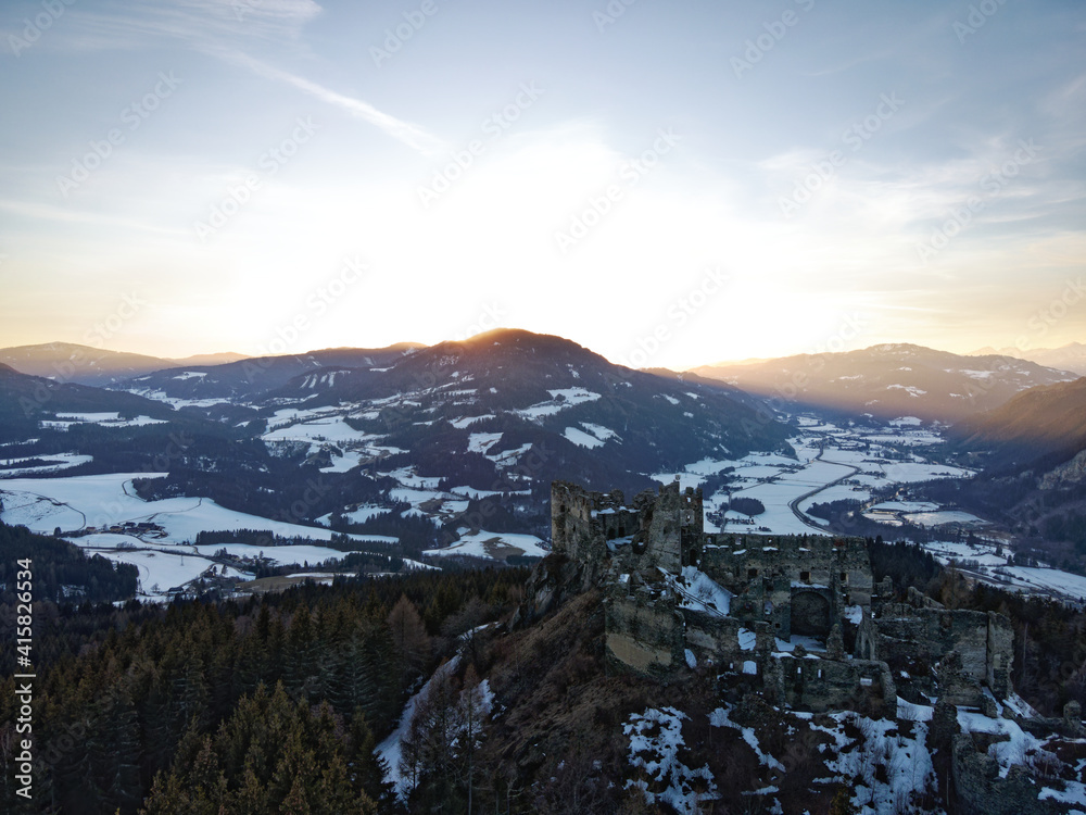 Sunset above the ruins of an old castle in the austrian alps.