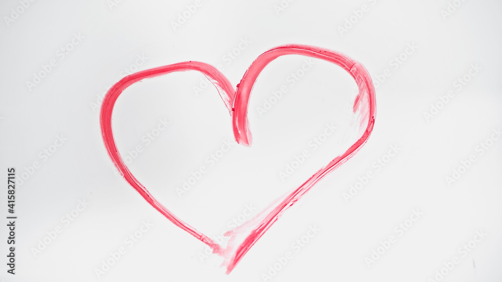 top view of drawn pink heart with lipstick on white