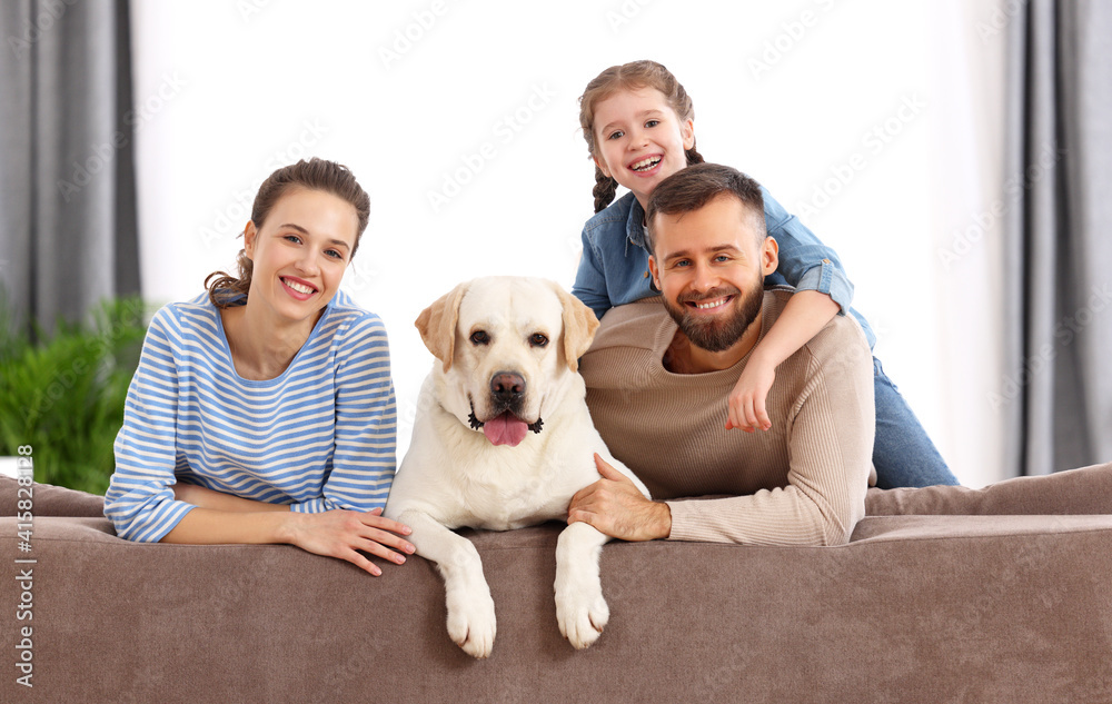 Happy idyllic family with kid and dog resting at home