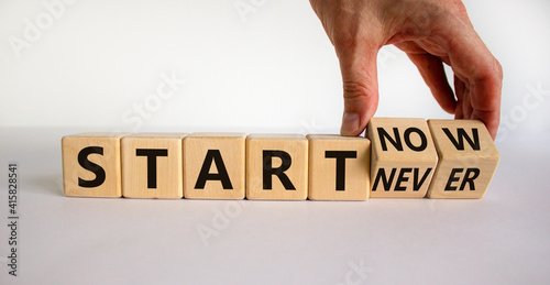 Start now or never symbol. Businessman turns wooden cubes and changes words 'start never' to 'start now'. Beautiful white background, copy space. Business and start now or never concept.