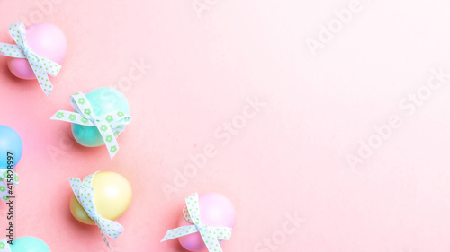 Easter background pink. Colourful egg with tape ribbon on pastel pink background in Happy Easter decoration. Flat lay, top view.