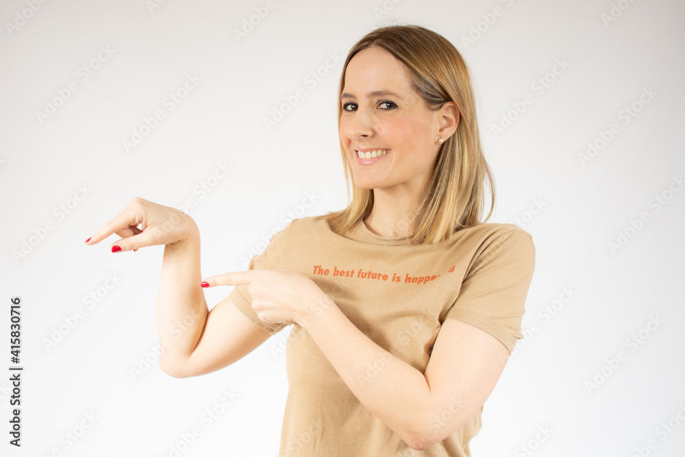 Young woman over isolated white background pointing fingers to the side Young woman over isolated white background pointing fingers to the side