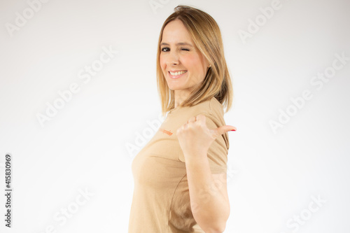 Smiling pretty young woman in casual t-shirt showing thumb up isolated over white background © Danko