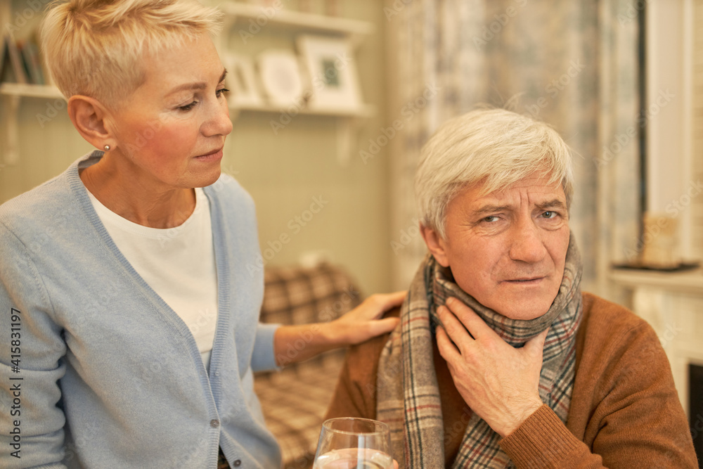 frustrated-elderly-male-wearing-scarf-suffering-from-pain-in-throat