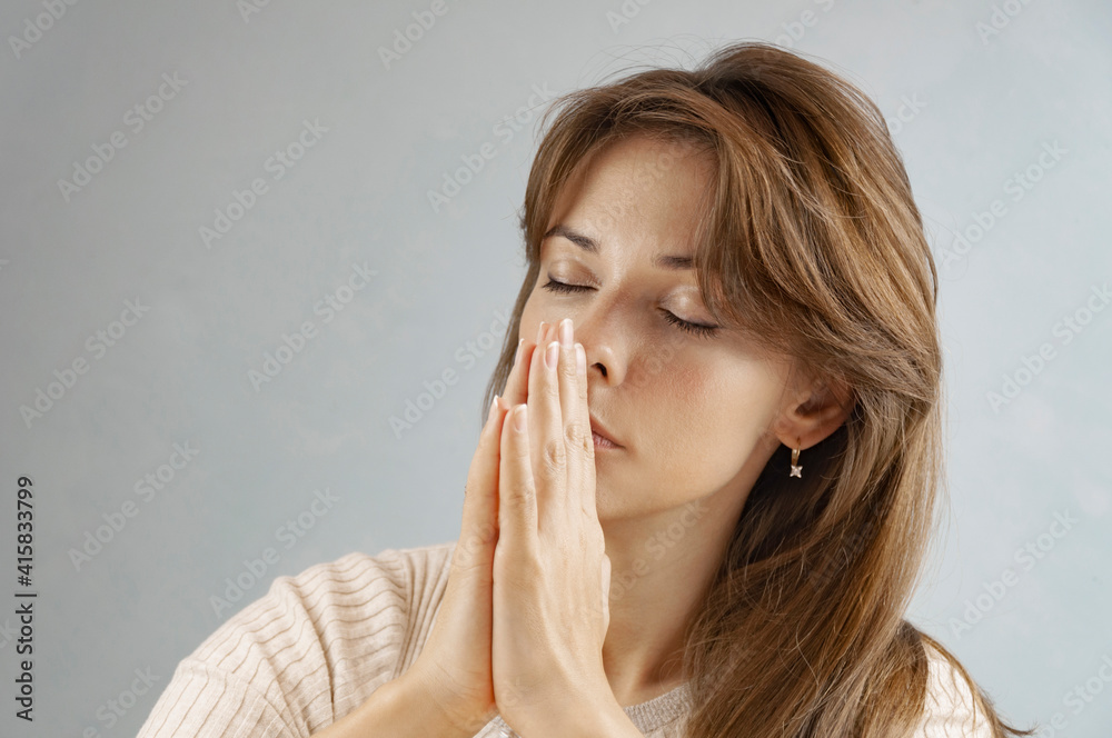 Concentrated brunette woman praying at home. Meditative Concept. Concentrated brunette woman praying at home. Meditative Concept.