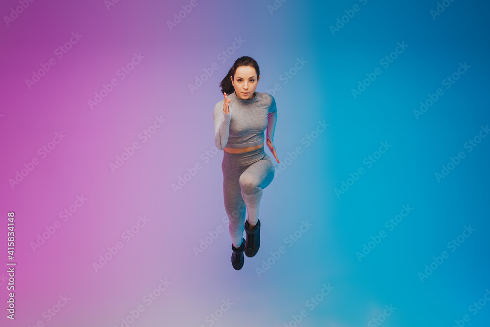 Fashion portrait of young fit and sportive caucasian woman on gradient background. Fit sportswoman posing, looks confident. Perfect body ready for summertime. Beauty, resort, sport concept. Flyer.