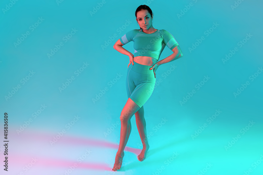 Portrait of young fit and sportive caucasian woman on gradient background. Fit sportswoman posing, looks confident. Beauty, resort, sport concept. Flyer