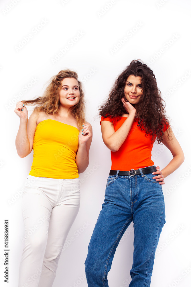 young pretty teenage girls friends with blond and brunette curly hairs posing cheerful isolated on white background, lifestyle people concept young pretty teenage girls friends with blond and brunette curly hairs posing cheerful isolated on white background, lifestyle people concept