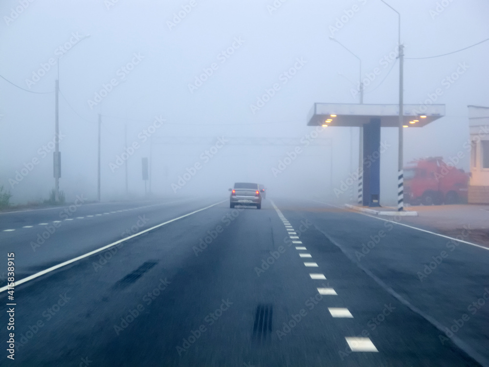 Cars in the fog. Bad weather and dangerous automobile traffic on the road. Cars in the fog. Bad weather and dangerous automobile traffic on the road.
