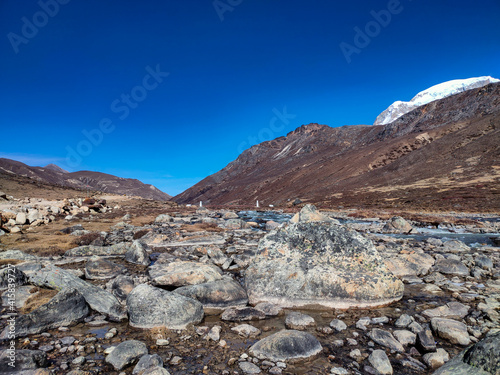 himalayan snow peak mountains with flowing cold snow streams and blue bright sky