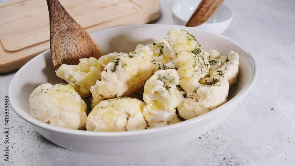 Cooking raw cauliflower with spices and oil on the table. Cooking vegan food concept. Cooking raw cauliflower with spices and oil on the table. Cooking vegan food concept.