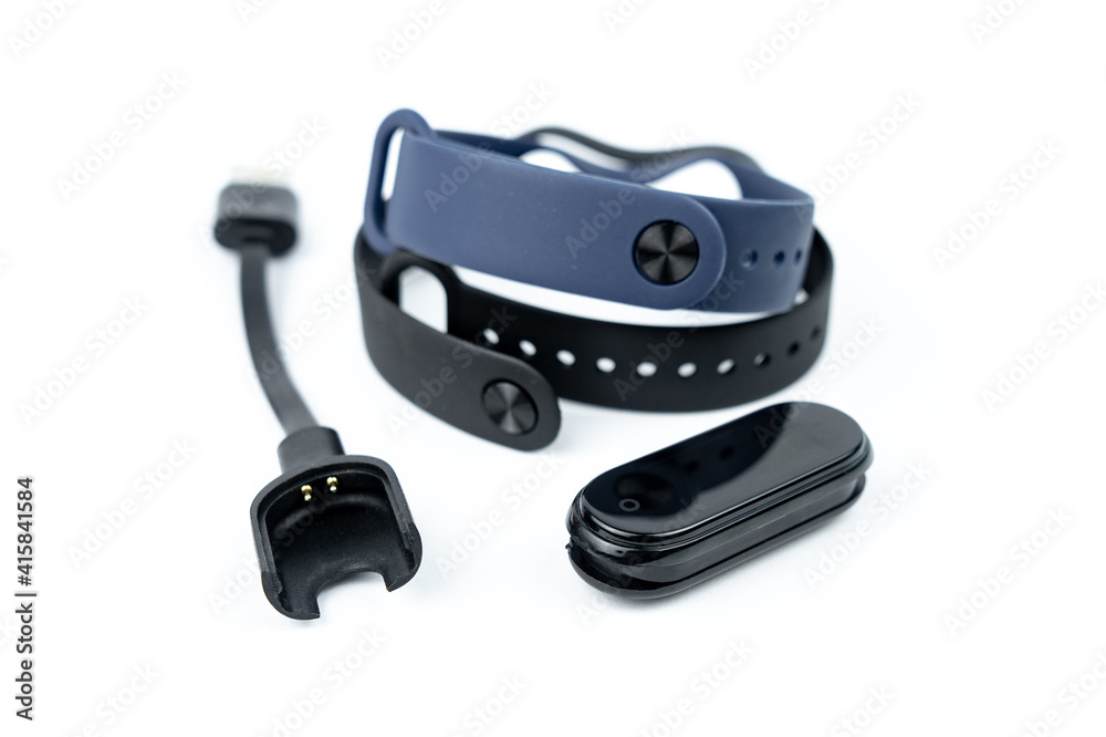 smart fitness bracelet with colored strap with charger isolated on white background smart fitness bracelet with colored strap with charger isolated on white background
