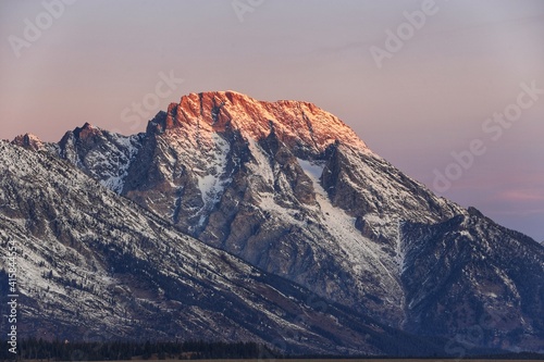 close up shot of morgenrot of Grand Teton mountain range during dawn time in winter at Glacier View Turnout