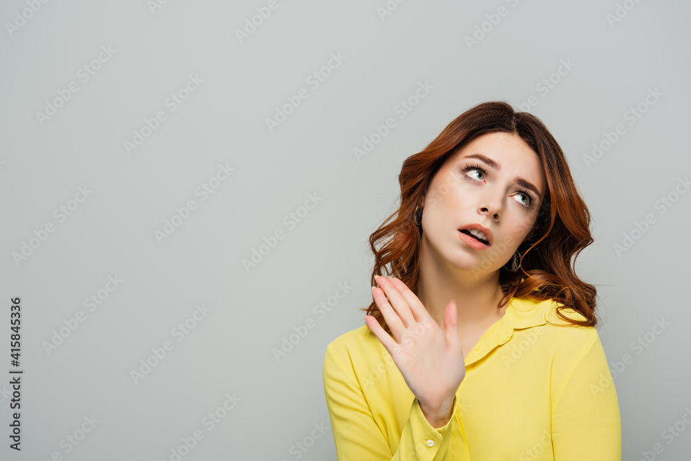 dissatisfied woman looking away and showing stop gesture isolated on grey dissatisfied woman looking away and showing stop gesture isolated on grey