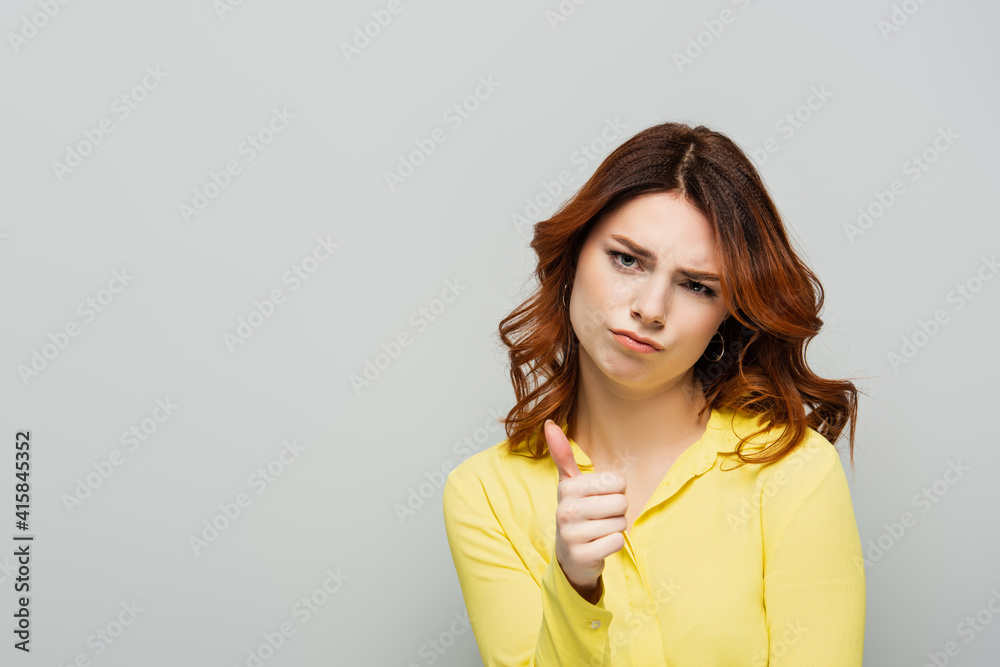 jealous woman showing thumb up while looking at camera isolated on grey jealous woman showing thumb up while looking at camera isolated on grey