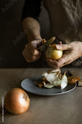 Male hands peeling onions