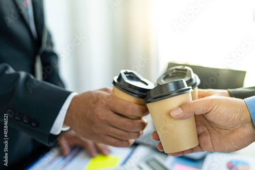A group of young businessmen hits a cup of coffee before they start working on a new morning. To find success in Workplace Modern Office.