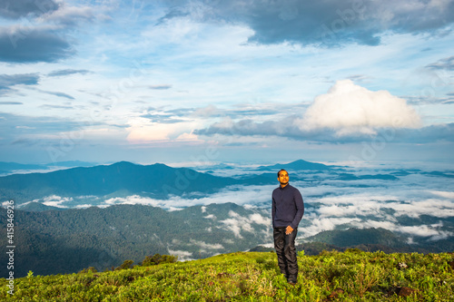 man isolated watching the serene nature at hill top with amazing cloud layers in background