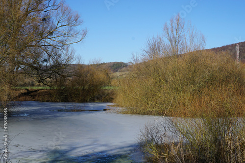 Ein kleiner gefrorener Teich an einem sonnigen warmen Wintertag