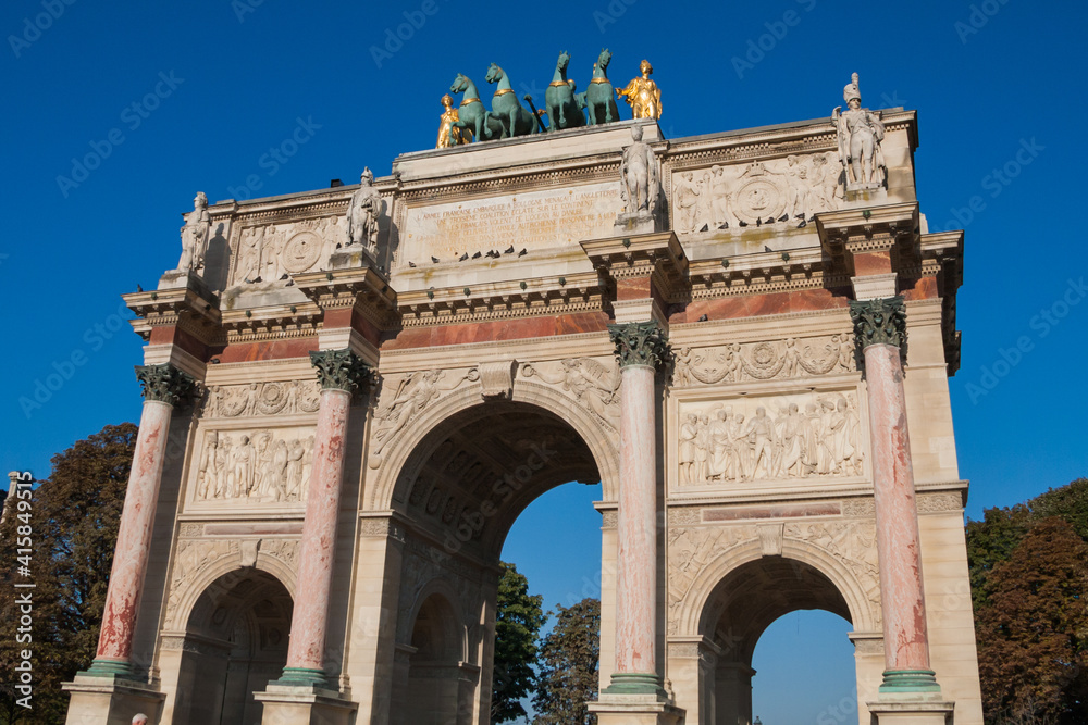 Arc de Triomphe du Carrousel (Triumphal Arch at Carrousel Place) monument is a tribute to Napoleon's military victories in Paris, France on an autumn day with clear blue sky