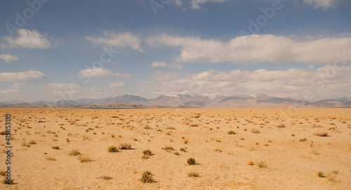 Desert landscape with snow-capped mountains around Karakul lake, Murghab district, Gorno-Badakshan, in the Pamir region of Tajikistan