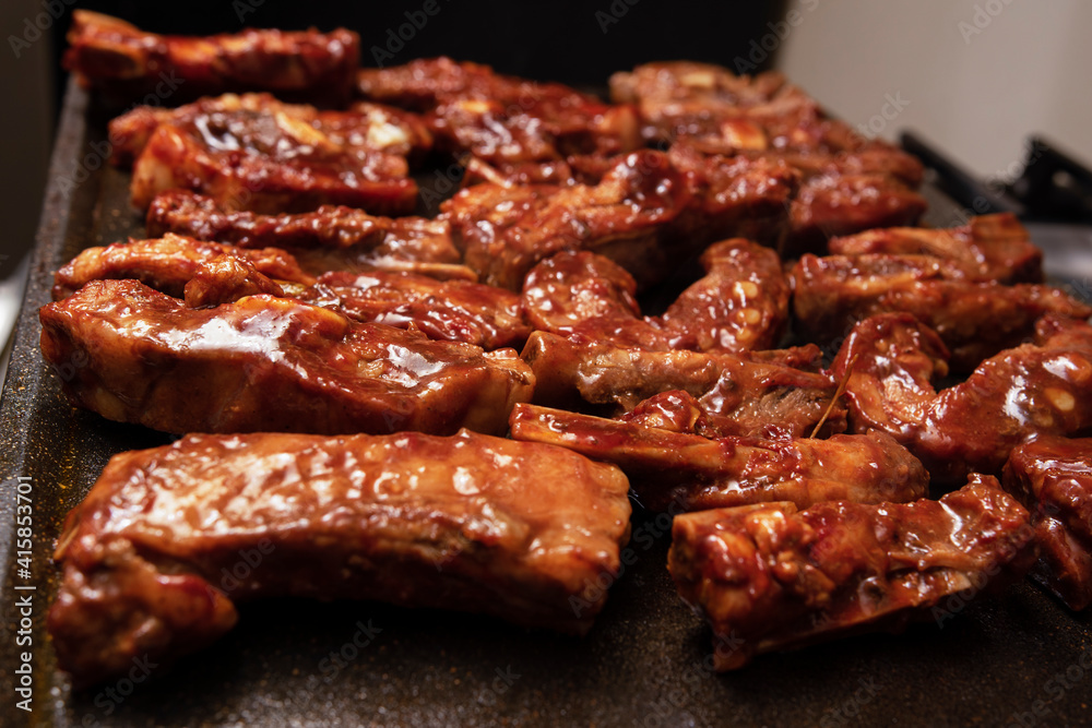 closeup of roasted pork ribs with barbecue sauce and caramelized with honey. Tasty homemade snack or small business ow