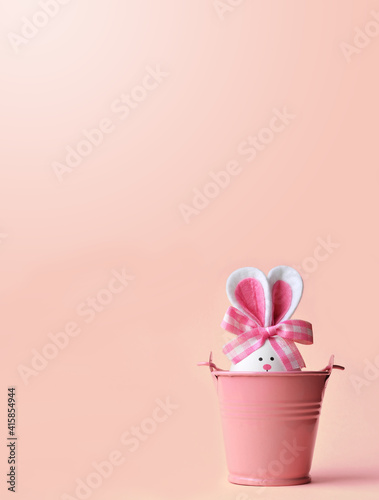 Easter holiday concept with cute handmade egg, bucket and bunny ears.