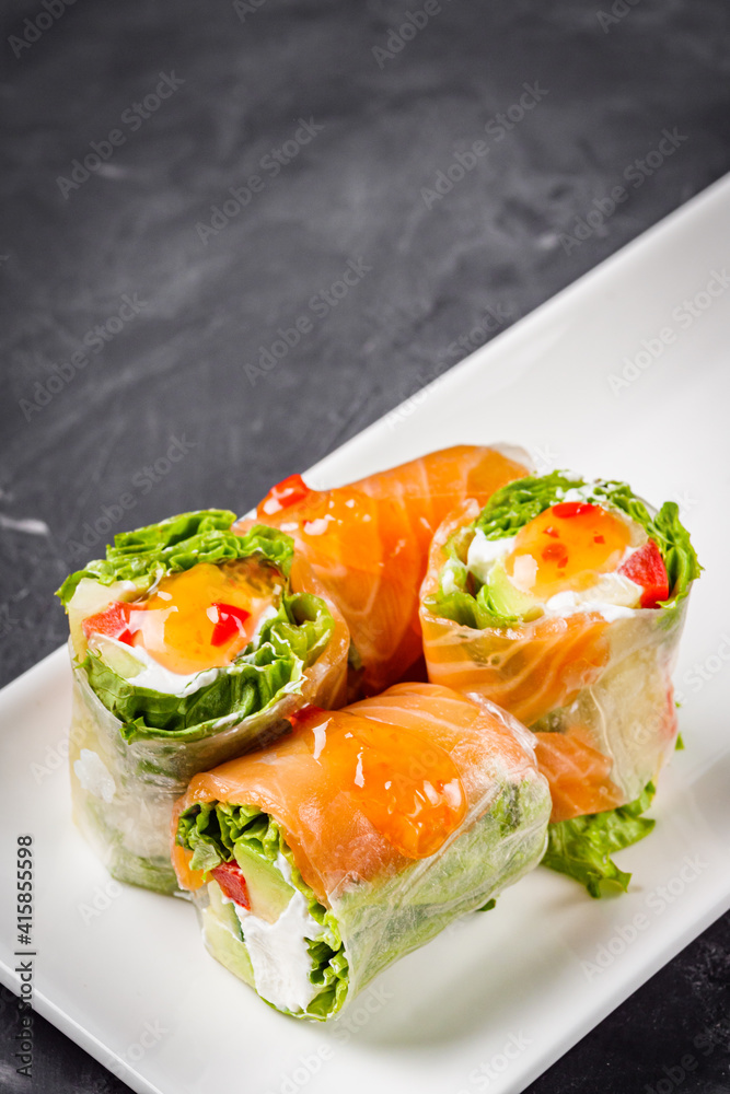 appetizing spring rolls with sea food and philadelphia cheese on a darck background appetizing spring rolls with sea food and philadelphia cheese on a darck background