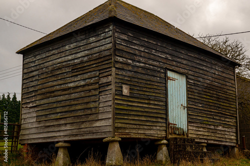 an old wooden farm out building perched on staddle stones photo