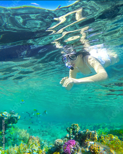 girl snorkeling underwater in the sea corals and fish