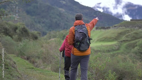 Couple walking to Archaeological inca ruins, in middle of the mountains, vitcos, road to vilcabamba, machu picc photo