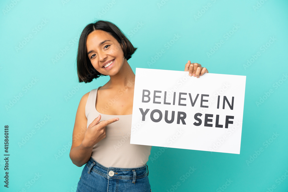 Young mixed race woman isolated on blue background holding We Want You board and pointing it Young mixed race woman isolated on blue background holding We Want You board and pointing it