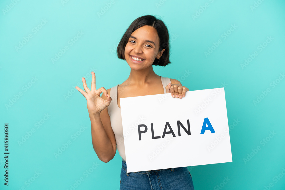 Young mixed race woman isolated on blue background holding a placard with the message PLAN A with ok sign Young mixed race woman isolated on blue background holding a placard with the message PLAN A with ok sign