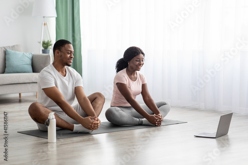 Cheerful african american couple having online yoga class