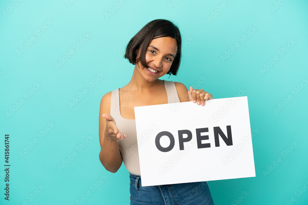 Young mixed race woman isolated on blue background holding a placard with text OPEN making a deal Young mixed race woman isolated on blue background holding a placard with text OPEN making a deal
