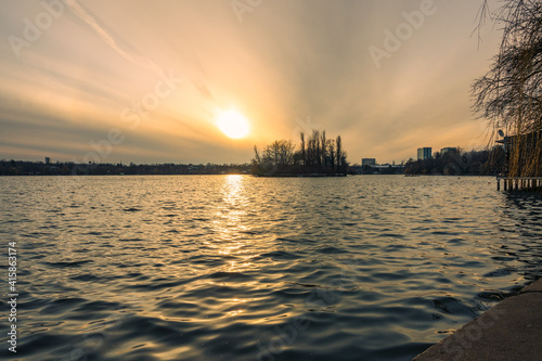 Obraz na płótnie Sunset over a lake in a city park w salonie