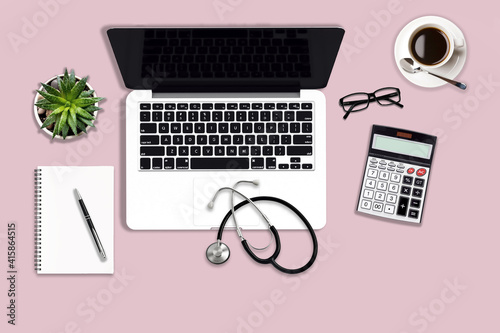 Mockup image of modern office desk with laptop computer, medical stethoscope, calculator, blank diary notebook, pen and coffee cup.