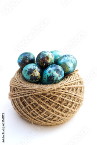 Easter colored eggs in a nest on a white background