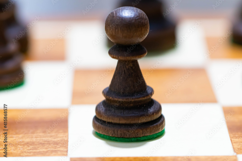 Playing wooden chess on a chessboard. Tactics and strategy. Black and white shapes. Playing wooden chess on a chessboard. Tactics and strategy. Black and white shapes.