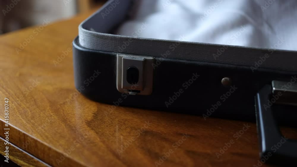 A Man Opens An Old Business Suitcase. A Black Vintage Briefcase Is Lying On A Wooden Table . A Man Opens An Old Business Suitcase. A Black Vintage Briefcase Is Lying On A Wooden Table .