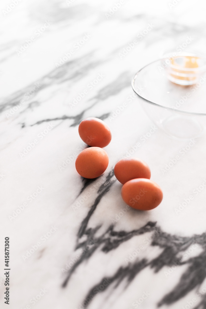 Four brown eggs on a marble table. A process of cooking with eggs Four brown eggs on a marble table. A process of cooking with eggs