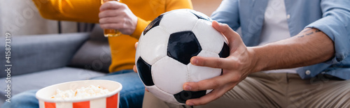 cropped view of man holding soccer ball near son on blurred background, banner © LIGHTFIELD STUDIOS