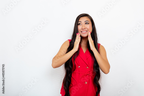 Surprised beautiful young Woman holds hand near the Face. White background. Surprised asian model looking away 