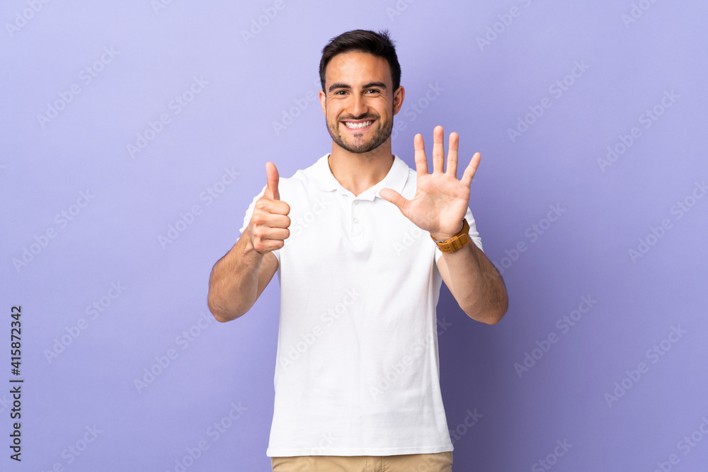 Young handsome man isolated on purple background counting six with fingers Young handsome man isolated on purple background counting six with fingers