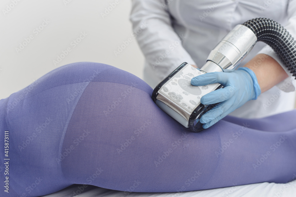 LPG, and body contouring treatment in clinic. Beautiful woman getting beauty therapy against cellulite with LPG machine on her buttocks LPG, and body contouring treatment in clinic. Beautiful woman getting beauty therapy against cellulite with LPG machine on her buttocks
