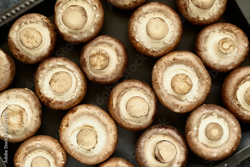 Fresh champignon mushrooms on baking sheet, top view, background