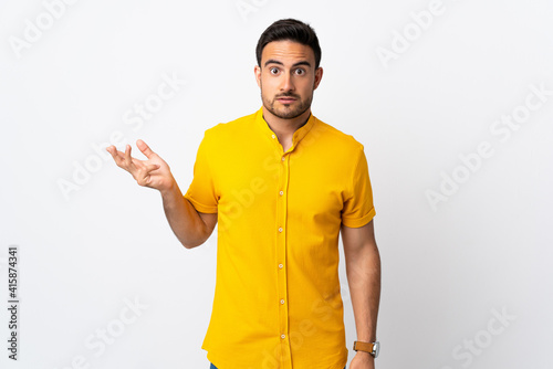 Young handsome man over isolated background making doubts gesture